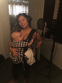 a woman holding a baby in a recording studio