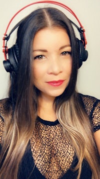 a woman wearing headphones and posing for a photo