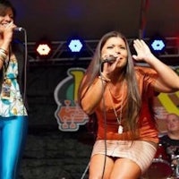 a group of women singing on stage at an event